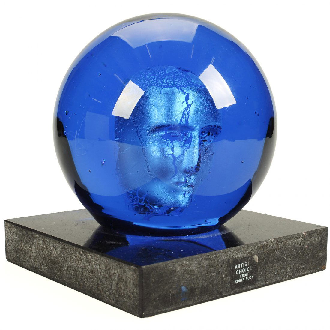 SKULPTUR, glas, BERTIL VALLIEN (1938-) för Kosta Boda: Klot med innefattat ansikte monterat på svart sockel i marmor. Etikettmärkt "Artist Choice from Kosta Boda". Signerad på sockel "Kosta Boda B.Vallien 7090336". Smärre slitage. Höjd 20 cm, sockeln