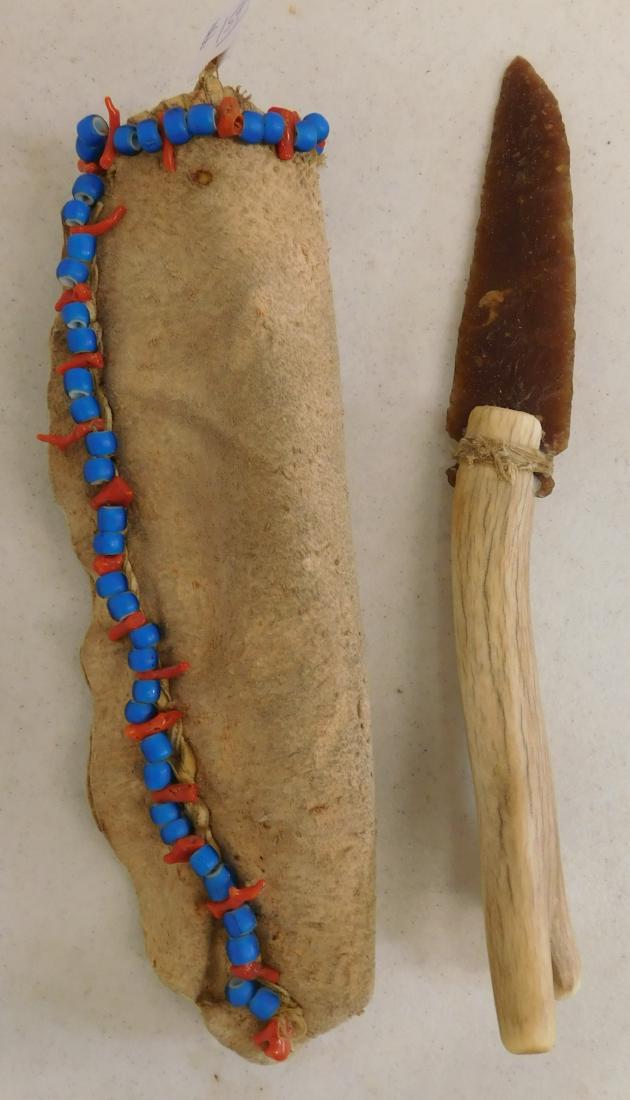 Stone Knife & Beaded Sheath: Stone Knife & Beaded Sheath, circa 1900. Made of knife river blade, deerhide, glass beads, bone handle. The item sheathed is 11" x 3" x 1", blade is 5" long. South Dakota. Translucent knife blade. Con
