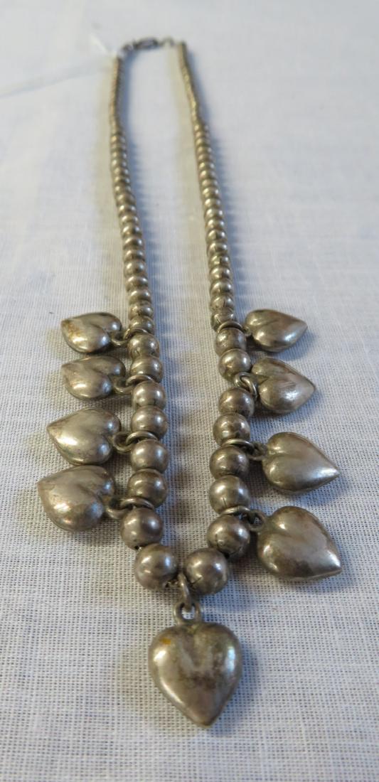 Mexican Sterling Silver Necklace w/Hearts: Mexican Sterling Silver Necklace w/Hearts, c. 1930s. Made of sterling silver, the item hangs 9" as worn. Weighs an approx. total of 36.9 grams. Mexico. 9 heart charms, silver beads are strung on a sma