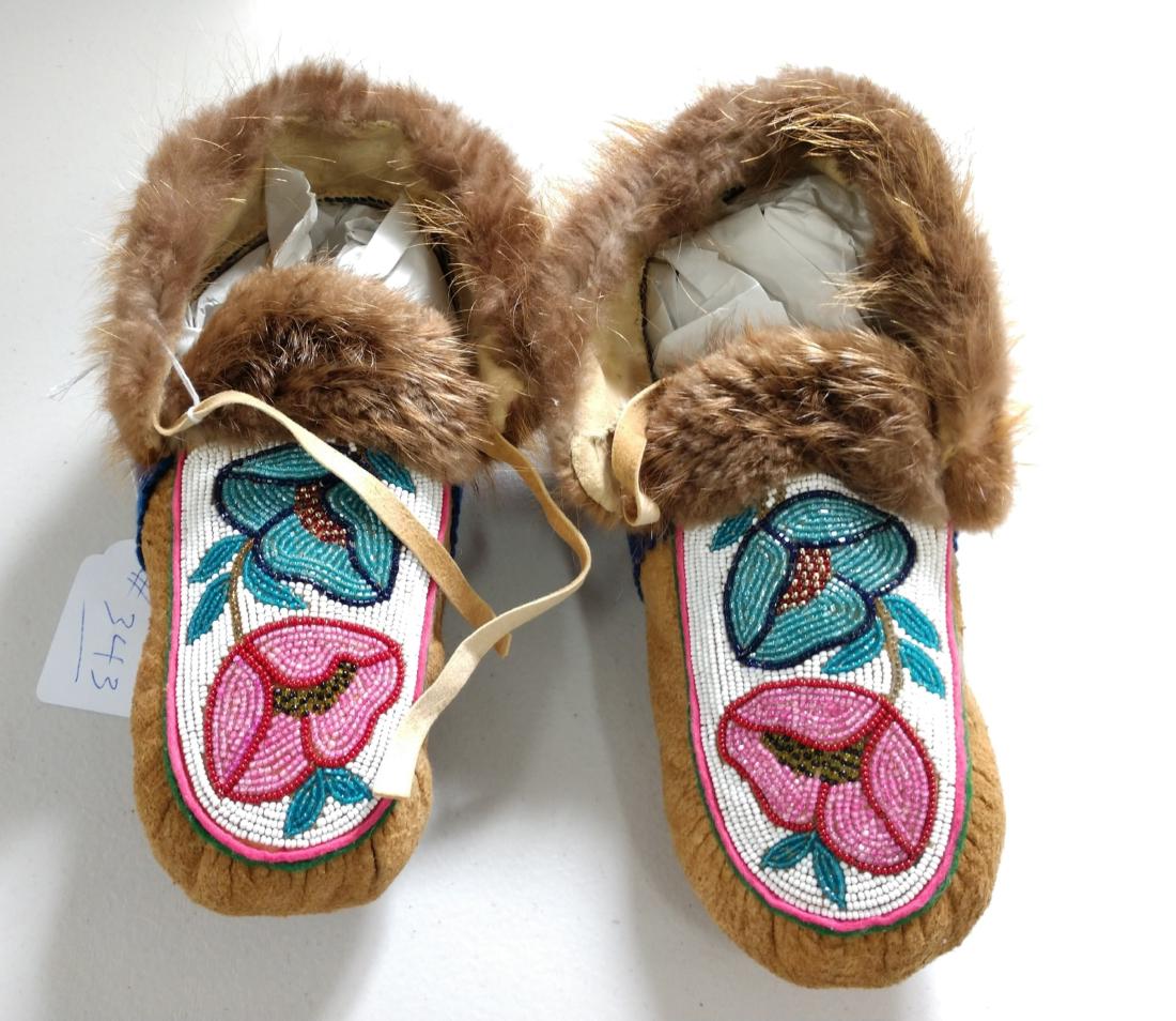 Cree Moccasins: Cree Moccasins, c. 1930s. Made of beaver cloth, moose hide and grass, the items each measure approx. 10" x 5". Canada. Condition: Good, one lace missing, see images. Shipping: $26.50 w/insurance and s