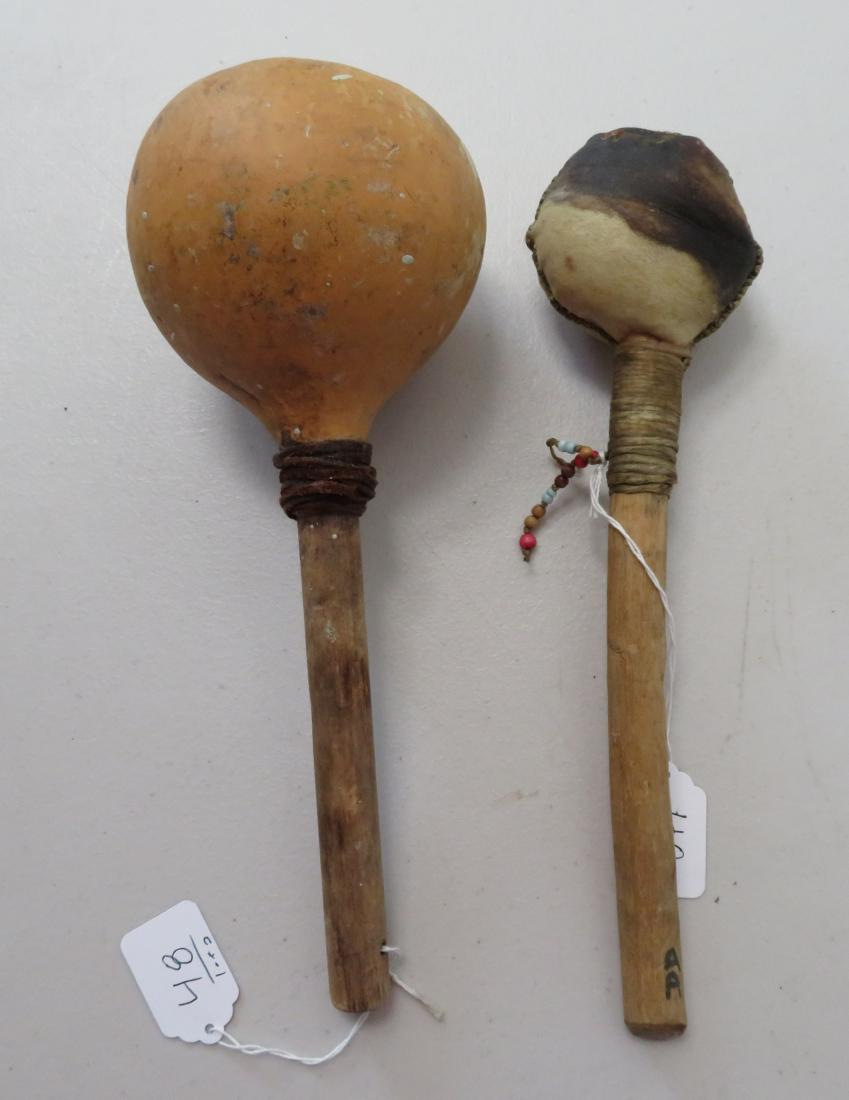 Pair of Navajo Rattles: Pair of Navajo Rattles, c. 1960s. Made of gourd, rawhide, sinew, leather, seed beads and turquoise, the items measures 4 1/4" x 11 1/2" and 12" x 2 1/2" x 3 1/2". New Mexico. Condition: Good, some wea
