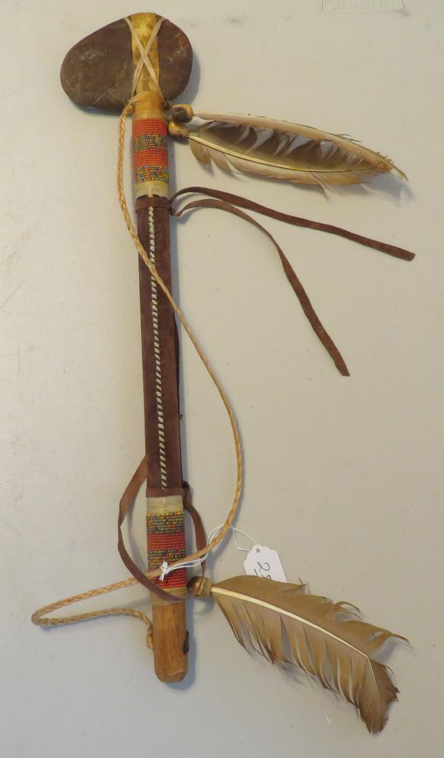 Plains Indian Club w/Beadwork: Plains Indian Club w/Beadwork, 20th century item. Made of stone, sinew, hide, glass beads, feathers, wood and leather, the item measures 21" x 4 1/2" x 1 1/4". Plains Indian. Nice beadwork and some ol