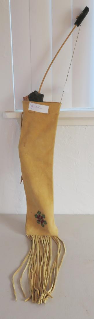 Beaded Deerskin Bag: Beaded Deerskin Bag, c. 1930s. Made of wood, deerskin and glass beads, the bow measures 30" x 2" and the bag measures 30" x 5". Sioux. Bear effigy wood bow. Condition: Some stains, see images. Shippin