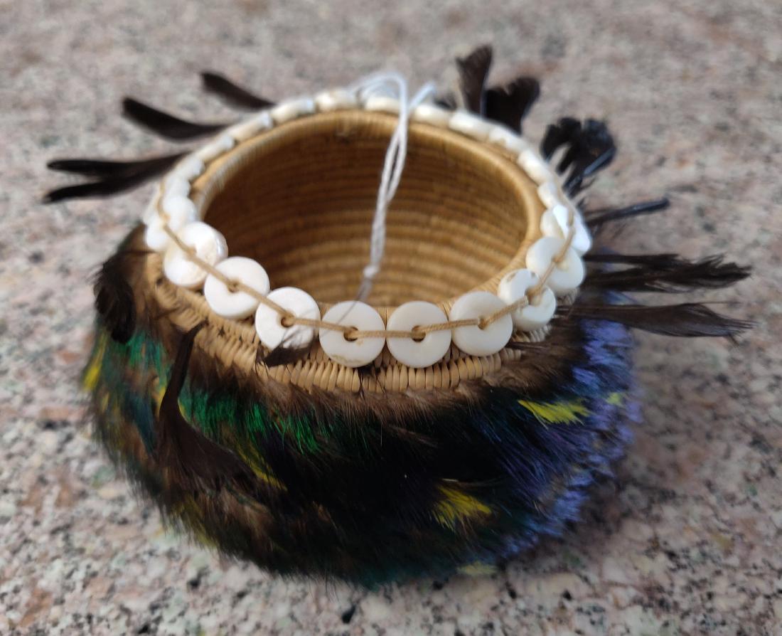 Pomo Gift Basket w/Shell & Feathers: Pomo Gift Basket w/Shell & Feathers, c. 1940s. Made of grass and shell with feathers, the item measures 3 1/4" x 3 1/2" x 1 5/8". The Pomo tribe basket weavers of Northern California have been interna