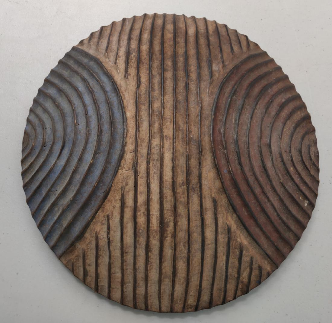 African Wood Shield: African Wood Shield, c. 1940s. Made of wood and paint, the item measures 16 1/2" round. African. Handle on back. Condition: Good, see images. Shipping: $32.50 USA estimate only, w/insurance and signat