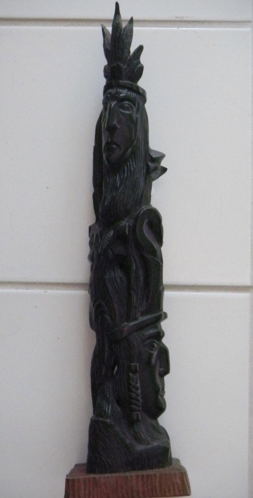 Ebony Wood Carving - Totem Pole like: The three dimensional totem pole like ebony wood carving of three native American faces from the 1960's. The carving is apprx 3 x 20 inches Shipping 10.00