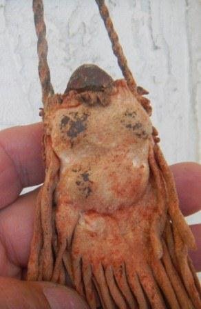 Rare Stone Effigy in Beaded Deerhide bag: Stone Effigy in Beaded Deerhide bag with fringe and ochre. The item is on a twisted deerhide lace. The item is extremely rare and is either a hunting fetish or a type of plains medicine bundle. It is 