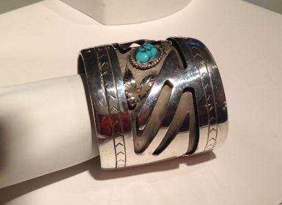 Large Sterling Silver Cuff Bracelet with Turquoise Cabo: Large Sterling Silver Cuff Bracelet with Turquoise Cabochon signed by JM. This bracelet has a 1 58 inch opening, it is 2 1/2 inches wide and weighs 192 grams. There is a large turquoise stone with lea