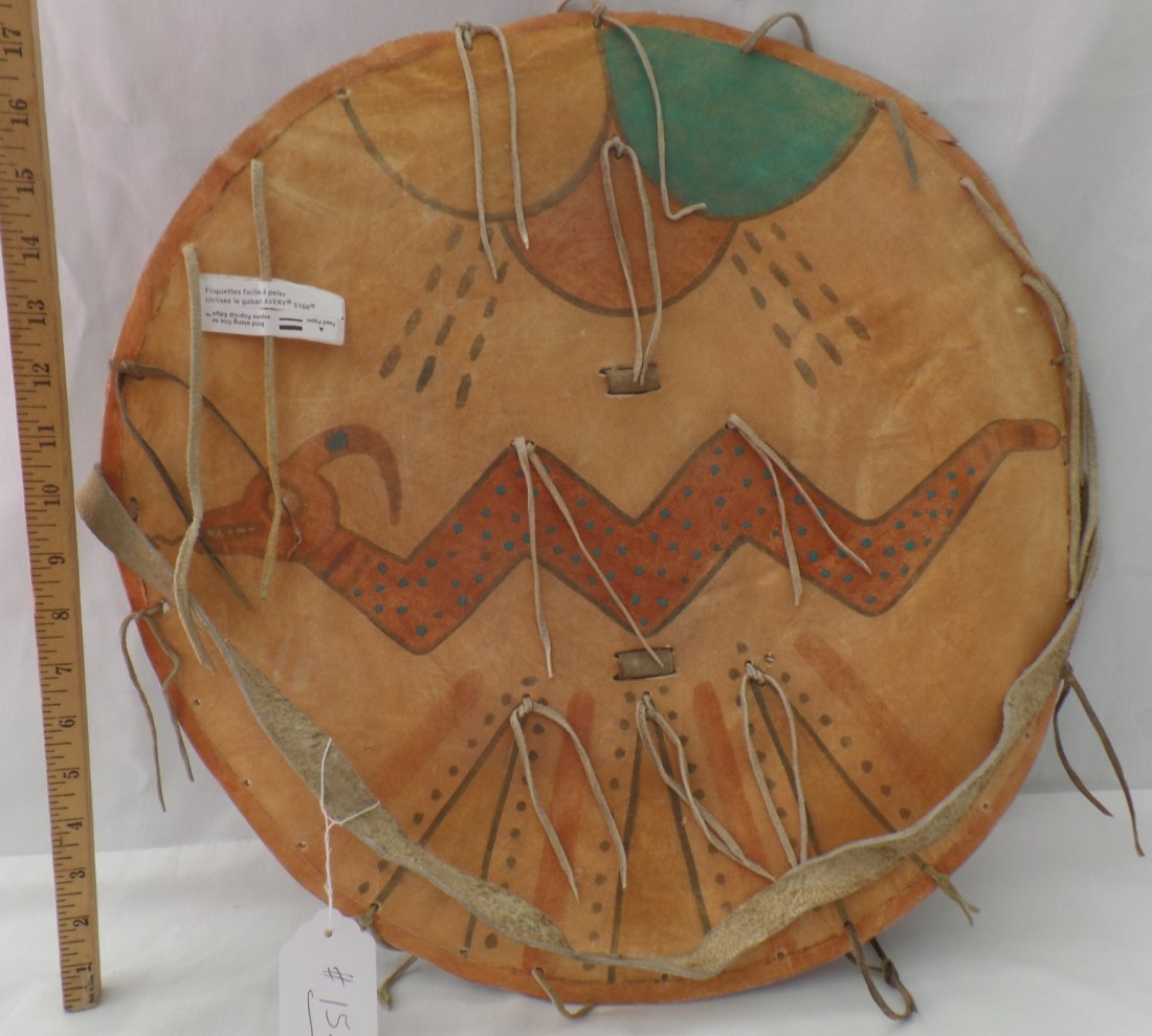 Pueblo Dance Shield: This is a 1930's Pueblo Dance Shield made from leather and thick cowhide. The Shield is 20 x 2 inches and from New Mexico, Pueblo. The shield has rain clouds and dragon. There are minor scuffs and sta