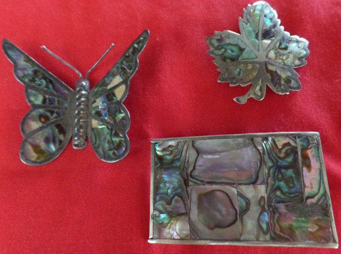 Group of Silver and Abalone Jewelry Pieces: Group includes butterfly 2 x 3 inches which is missing a couple of pieces and is marked Plata 925, CJL; Belt Buckle 1 1/2 x 3 inches and Maple leaf 2 x 2 1/2 inches. Approximately weighing 26 grams. C