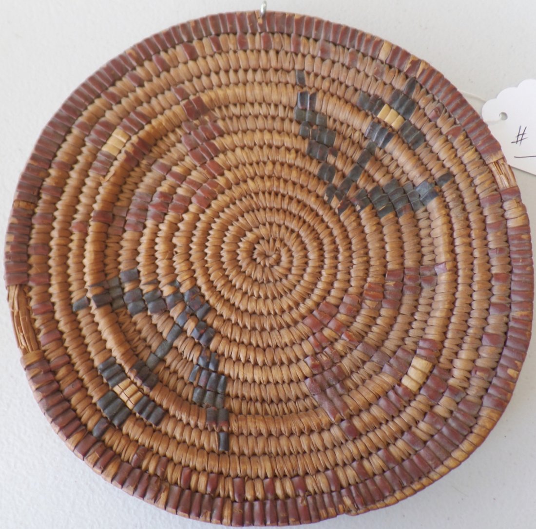 Northwest Coast Basket: Northwest Coast Basket. Circa 1900. Made of cedar and bark. Measures 8" x 8" x 1". From the Thompson River area. Features 2 black plant-like objects and 2 brown/red. Wonderful bark basket. Condition: 