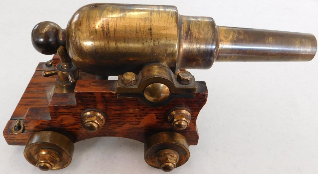 Old Brass Cannon: Old Brass Cannon, circa 1850. Made of brass and an oak base. Item measures 9" x 4" x 4", weighs 5 pounds. Believed to be American-made. This came from a large collection of small cannons, from a Victo