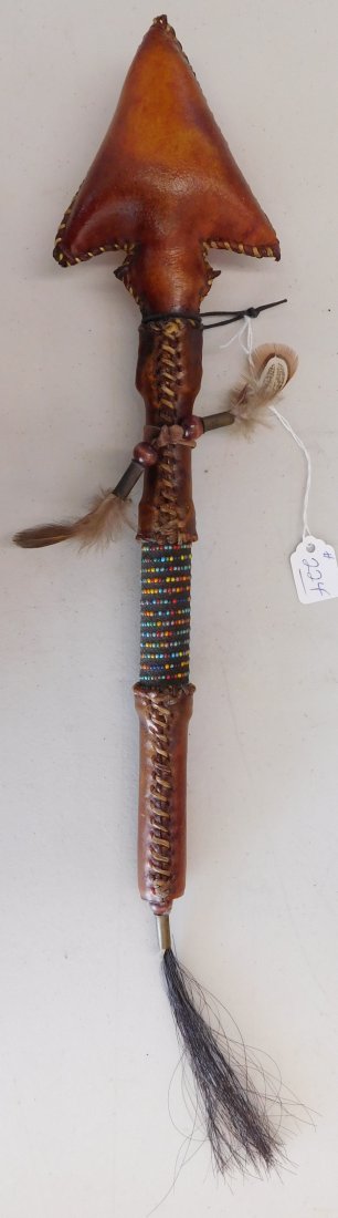 Plains Indian Dance Rattle: Plains Indian Dance Rattle, modern item. Made of rawhide, feathers, horsehair, spent brass shells and glass beads, this item measures 18" x 3.5" x 2". Sioux. Has a shape of an arrow! Nice rattle sound