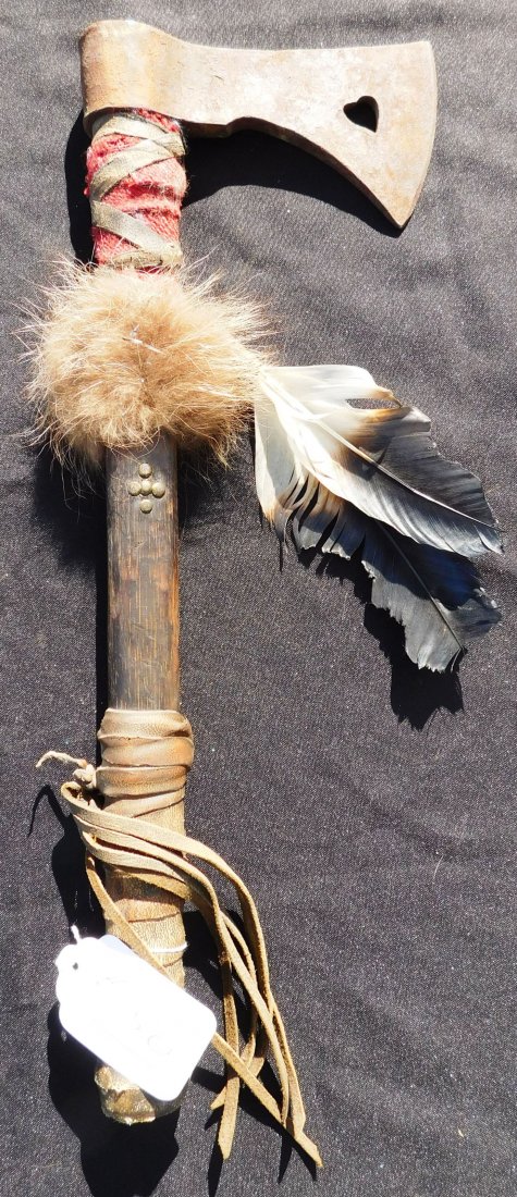 Plains Indian Trade Tomahawk: Plains Indian Trade Tomahawk, circa mid-20th century. Made of rawhide, wood, fur and feathers, cloth and brass tacks, item measures 18" x 6.5" x 1.5". From the Dakotas, Sioux. Item has a heart-shaped 