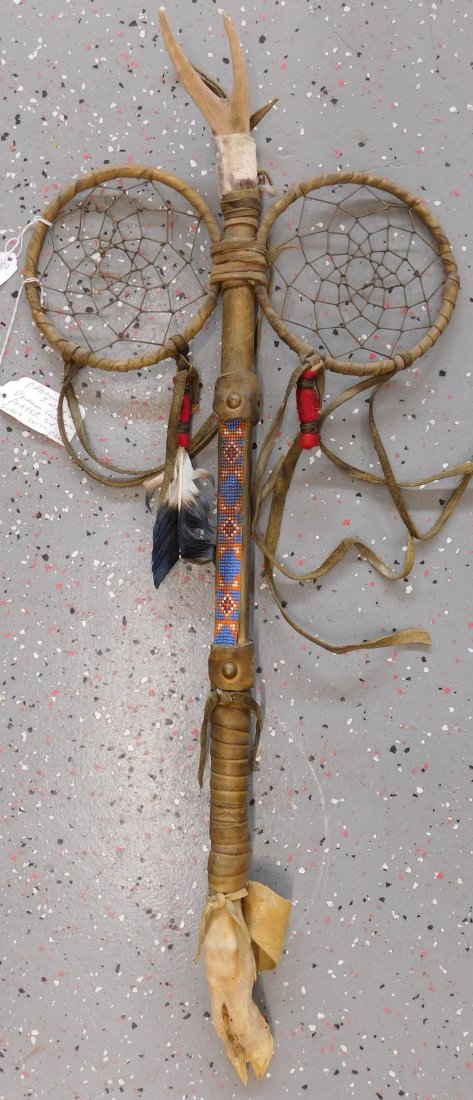 Plains Indian Dreamcatcher Prayer Staff: Plains Indian Dreamcatcher Prayer Staff, circa mid-20th century. Item measures 30 x 13 x 2 inches. Item is made of wood, wrapped in hide, has alter bone and hoof, glass beadwork, brass tacks, and leat