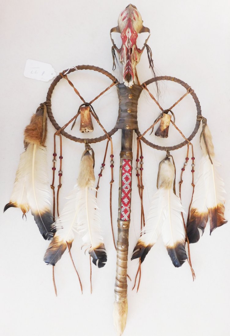 Plains Indian Coyote Medicine Wand: Plains Indian Coyote Medicine Wand, circa 1900. Item is made of feathers, skull bone, fur, rawhide, wood, glass beads and brass tacks. Item measures 31" x 15" x 5". Sioux, Dakota. Much polish on handl