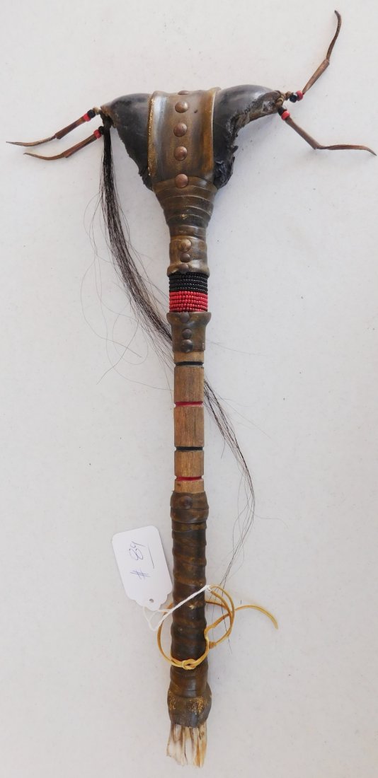 Plains Indian Buffalo Rattle Toe: Plains Indian Buffalo Rattle Toe, circa 1900. Item consists of paint, rawhide, brass tacks, teeth, wood, tin cones, buffalo toes and glass beads. Item measures 21" x 6" x 2". Dakota, Sioux. Condition: