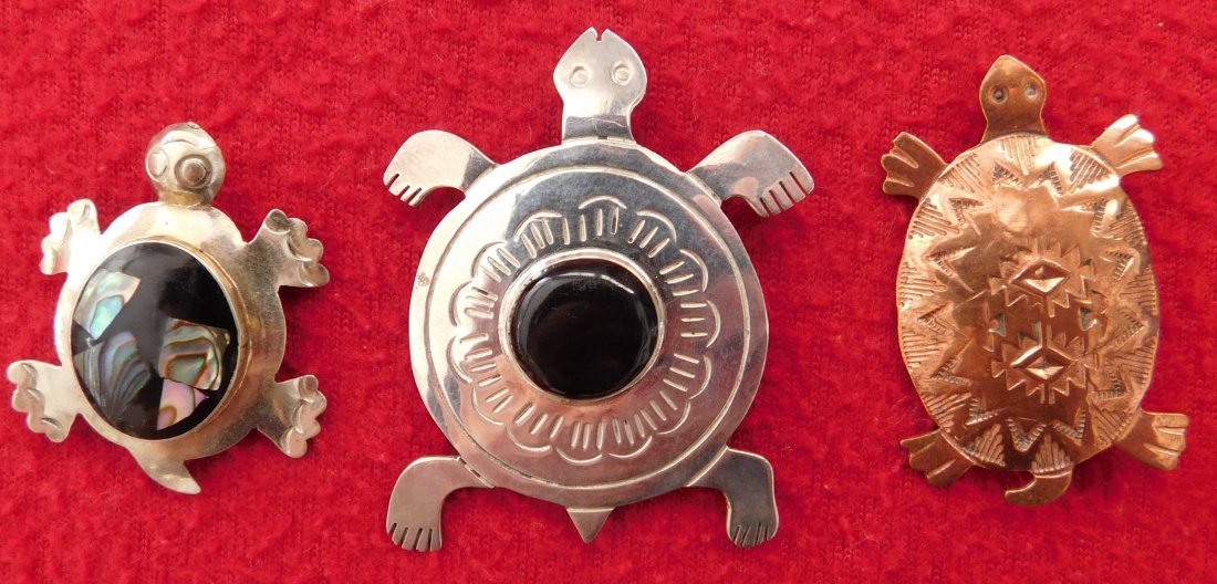 3 Turtle Pins: 3 Turtle Pins, circa 1970s or later. Made of copper, german silver, jet and abalone, the items range from 1.25" x 1" to 1.75" x 1.5". Navajo and Mexican items. Nice handstamping on the Navajo copper p