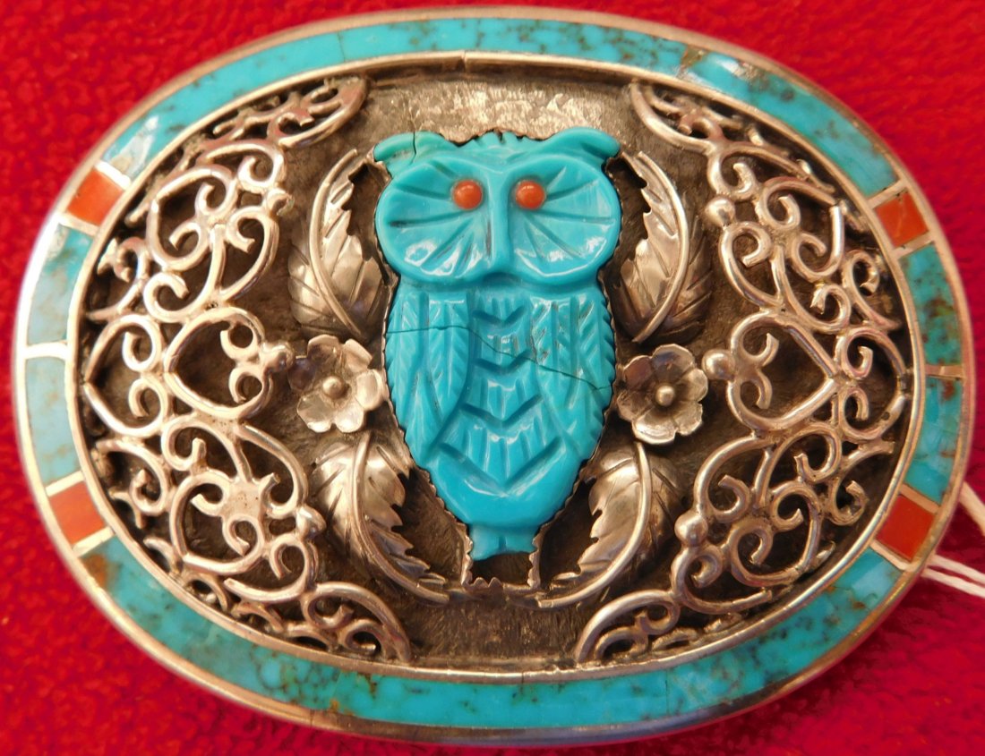 S. Kuehler Carved Turquoise Owl Buckle: S. Kuehler Carved Turquoise Owl Buckle, circa 1990s. Made of coral, sterling silver, and turquoise, this item measures 3.5" x 3" x 0.75" and weighs approx. 88.2 grams. Nice coral eyes on this finely c