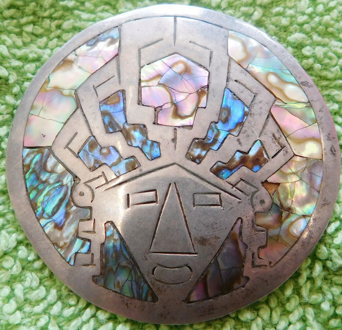 Mexican Sterling Silver & Abalone Pin: Mexican Sterling Silver & Abalone Pin, circa 1950s. Made of sterling silver and abalone, the pin measures 2 1/8" x 2 1/8", weighing 11.7 grams. Signed JB, .925. Nice pre-columbian-style Mezcala face w