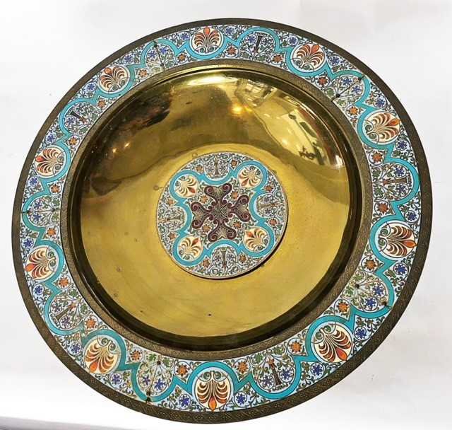 AESTHETIC MOVEMENT CHAMPLEVE ENAMEL ON BRASS BOWL: AESTHETIC MOVEMENT CHAMPLEVE ENAMEL ON BRASS BOWLCirca 1880, formerly an Ecclesiastical water basin or baptismal font. The shallow basin with center enamel plaque with a stylized cross, the rim with