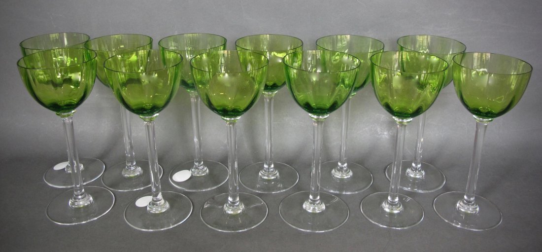 TWELVE GREEN & COLORLESS GLASS WHITE WINE GLASSES: SET OF TWELVE GREEN AND COLORLESS GLASS WHITE WINE GLASSES Unsigned. The transparent green glass bell-shaped bowls above a plain colorless glass stem with circular foot. Height 7.5 in., Diameter of bo