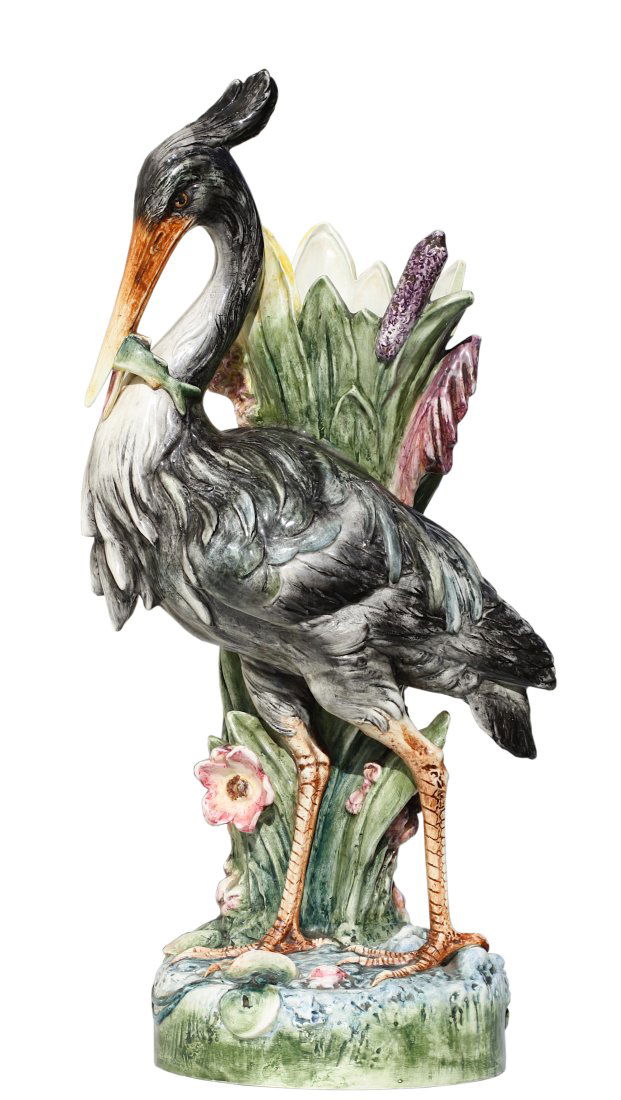 A Majolica Flower or Stick Stand in the Form of a Stork: A majolica flower or stick stand in the form of a stork naturalistically modelled, the wading bird feeding and standing on rockwork before bulrushes and iris, impressed marks 72cm., 28.37 in. high