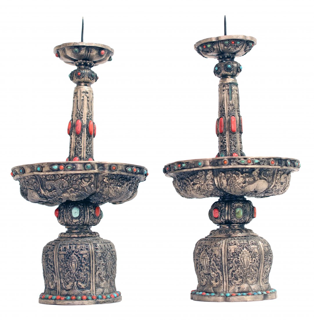 PAIR OF CHINESE MONGOLIAN SILVER PRICKET STICKS, 20TH C: A PAIR OF CHINESE MONGOLIAN SILVER PRICKET STICKS, 20TH CENTURY Repoussé design in silver, bejeweled with semi-precious stones, candle spike at top, and large drip tray. Height 22in. (56cm.) by Width