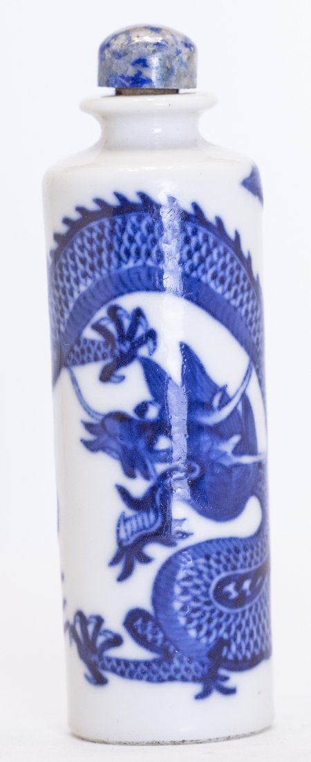 CHINESE BLUE AND WHITE PORCELAIN SNUFF BOTTLE: CHINESE BLUE AND WHITE PORCELAIN SNUFF BOTTLE Qing Dynasty, 19th/20th Century. Dragon design, along with a sodalite stopper. Mounted on a round wood stand. Height 3 3/4 inches.