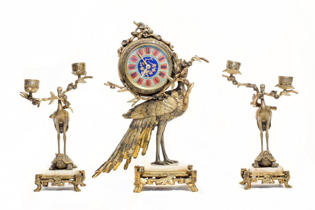 FRENCH ORMOLU AND ALABASTER CLOCK GARNITURE: FRENCH JAPONISME STYLE ORMOLU AND ALABASTER THREE-PIECE CLOCK GARNITURE Late 19th century. Retailed by Theodore B. Starr, New York. Comprising a clock and a pair of two-light candelabra; the drum form