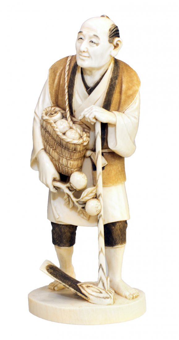 JAPANESE CARVED AND STAINED IVORY FIGURE: JAPANESE CARVED AND STAINED IVORY FIGURE Meiji Period (1868-1912), 20th Century. Signed within a cinnabar seal. Of a standing farmer carrying a basket of fruits and holding a large hoe. Height 7 1/2 i