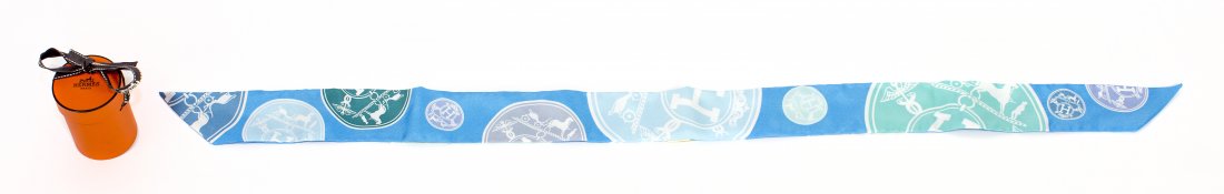 HERMES "CONFETTIS D'EX-LIBRIS" BLEU AZUR TWILLY SCARF: PROPERTY OF A PALM BEACH LADY: HERMES "CONFETTIS D'EX-LIBRIS" BLEU AZUR TWILLY SCARF Signed Hermes. Label marked Made in France. 100% Silk. Length 34 inches. Together with original gift box.