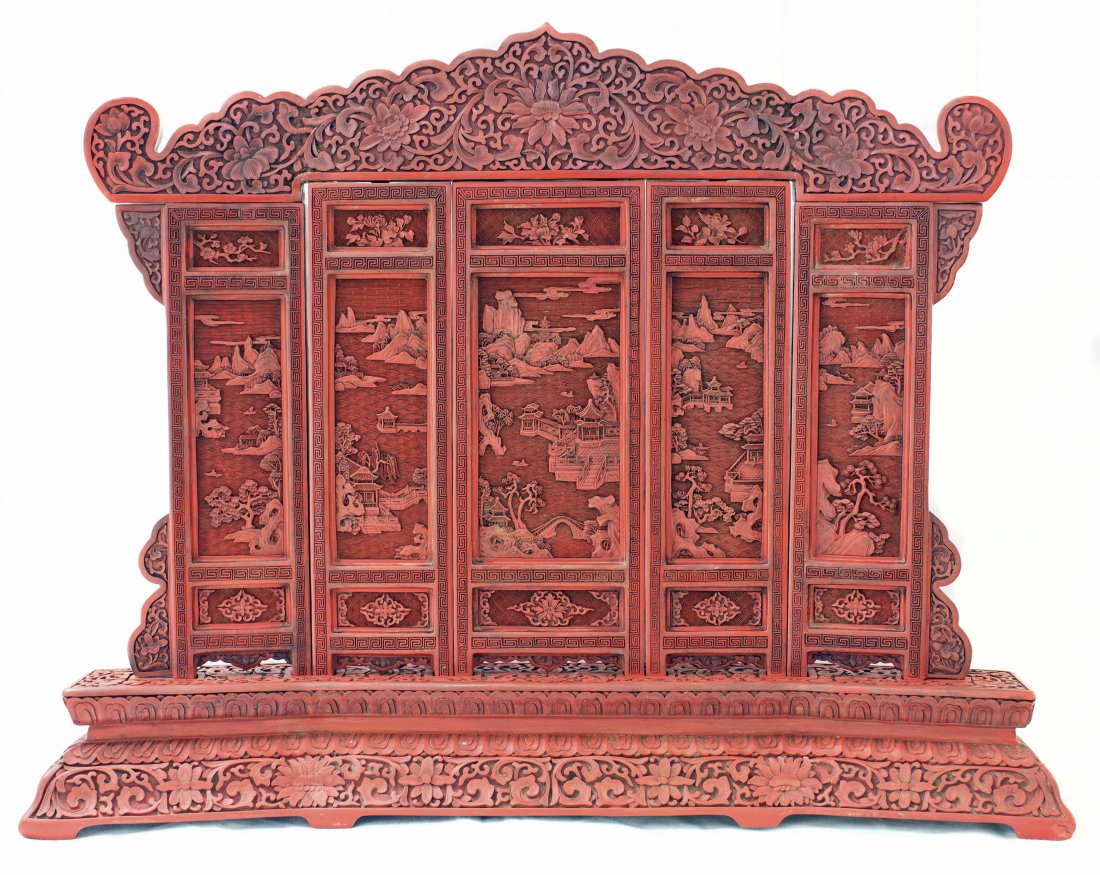 CHINESE CARVED CINNABAR RED LACQUER TABLE SCREEN: CHINESE CARVED CINNABAR RED LACQUER TABLE SCREEN The five rectangular panels carved with intricate pictorial scenes through layers of cinnabar lacquer, with a scroll form finial. Mounted on a carved c