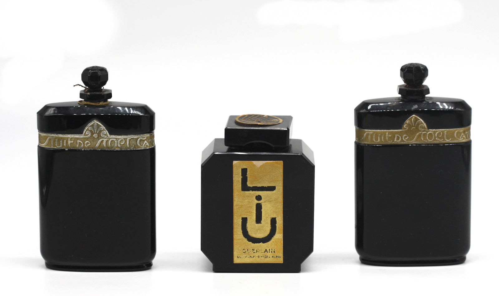 .Three French Art Deco Black Glass Perfume Bottles: .Three French Art Deco Black Glass Perfume Bottles. The first, Guerlain Liu, produced in 1929, underside etched Guerlain Made in France and with paper labels, square with canted corners and square sto