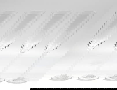 Set of Four Lalique Colorless Crystal Champagne Flutes: Set of Four Lalique Colorless Crystal Champagne Flutes Etched signature Lalique France. Each tapered cylindrical bowl on a squared stem pierced on all sides with open scrollwork, on a circular foot.