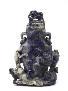 Chinese Carved Sodalite Covered Vase: Chinese Carved Sodalite Covered Vase The vase-shaped vessel with elephant and loose ring handles, depicting in high relief swirling ribbons with numerous fu-dogs at play, the cover with a fu-dog. 