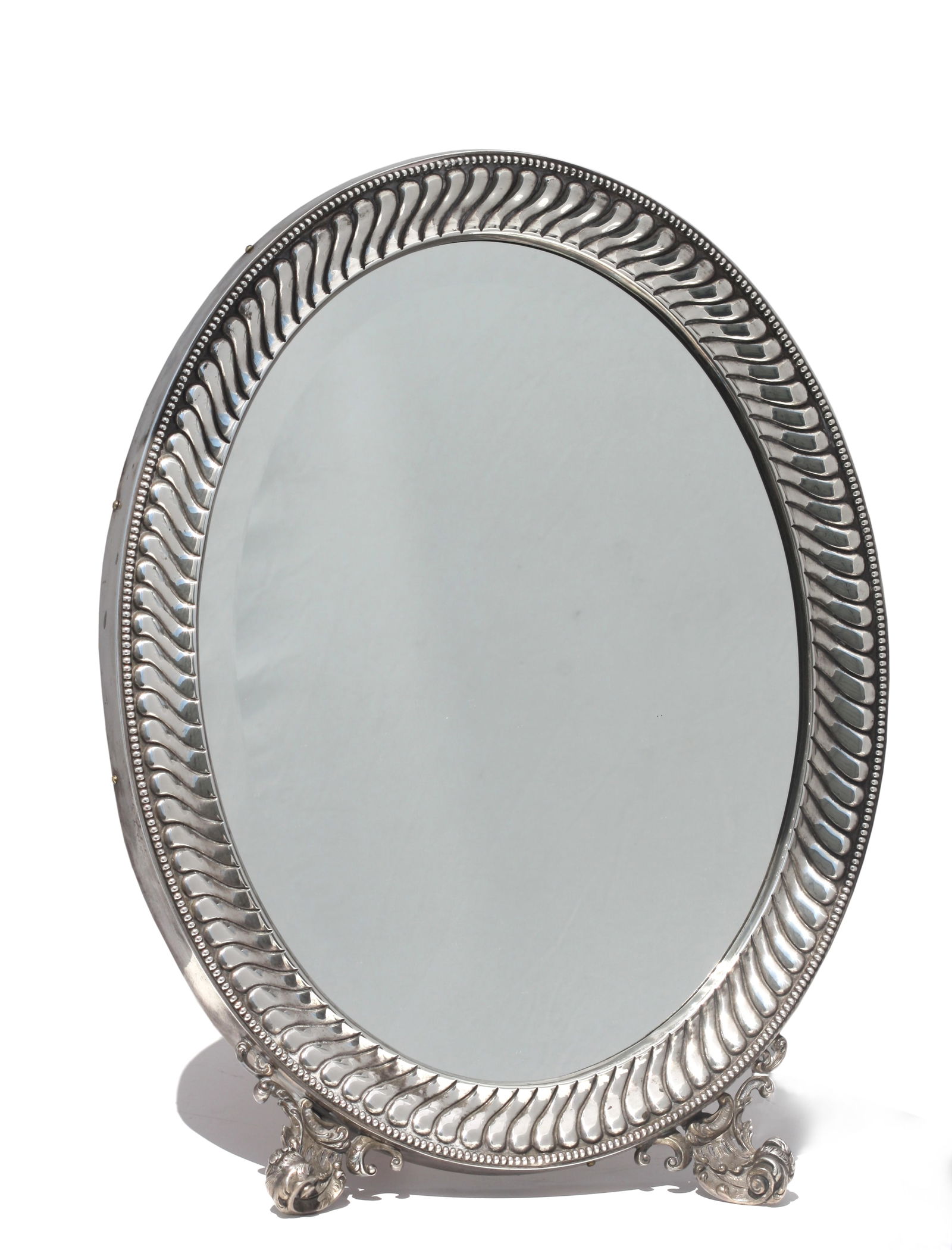 Continental Neoclassical Silver Oval Dressing Mirror,: Continental Neoclassical Silver Oval Dressing Mirror, 19th Century, Italian/French, marked. The oval swirled gadrooned surround with beaded border, on two foliate scrolled feet, with wood backing with