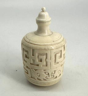 Chinese Archaic Style Carved Master Snuff Bottle: Chinese Archaic Style Carved Master Snuff Bottle The cylindrical footed body carved with a stylized Greek key and masks, the tall shaped neck surmounted by a domed cap with bead finial. Height