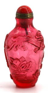 Chinese Molded Peking Glass Snuff Bottle: Chinese Molded Peking Glass Snuff Bottle The transparent pink cylindrical body molded with a chimera and various objects, with a coral cap and a spoon. Height 2.75 in. Snuff bottles were personal