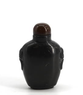 Chinese Carved Black Basalt Snuff Bottle: Chinese Carved Black Basalt Snuff Bottle Of tapering ovoid form, the sides carved with stylized mask and ring handles, with a mineral cap and a scoop. Height 2.5 in. Snuff bottles were personal