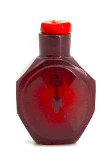 Chinese Ruby-Red Peking Glass Snuff Bottle: Chinese Ruby-Red Peking Glass Snuff Bottle The transparent faceted circular vessel with a cylindrical neck, with a coral and seed pearl cap and a spoon. Height 2.75 in. Snuff bottles were personal