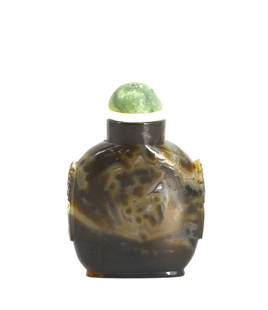 Chinese Mottled Agate Snuff Bottle: Chinese Mottled Agate Snuff Bottle The shaped footed circular body with an overall mottling of gray to brownish black, the sides carved with mask and stylized ring handles, with a domed celadon green