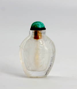 Chinese Colorless Rock Crystal Snuff Bottle: Chinese Colorless Rock Crystal Snuff Bottle The tapering ovoid body carved on one side in low relief with a stylized motif, with a green mineral cabochon cap, with scoop. 2 in. Snuff bottles