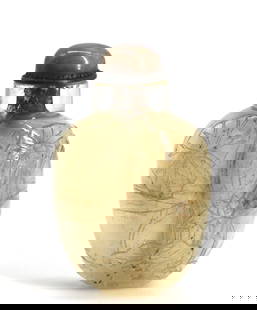 Chinese Carved Rock Crystal Snuff Bottle: Chinese Carved Rock Crystal Snuff Bottle The tapered ovoid body carved with foliage, with a domed quartz cap with scoop. Height 2.75 in. Snuff bottles were personal objects of luxury and