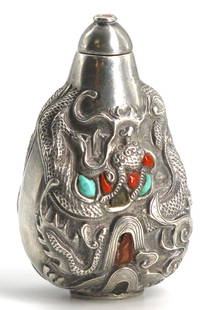 Sino-Tibetan Silvered Metal Mounted Snuff Bottle: Sino-Tibetan Silvered Metal Mounted Snuff Bottle The pear-form body repousse decorated with a swirling dragon amidst cloud bands, further decorated with inlaid turquoise and carnelian, with a domed