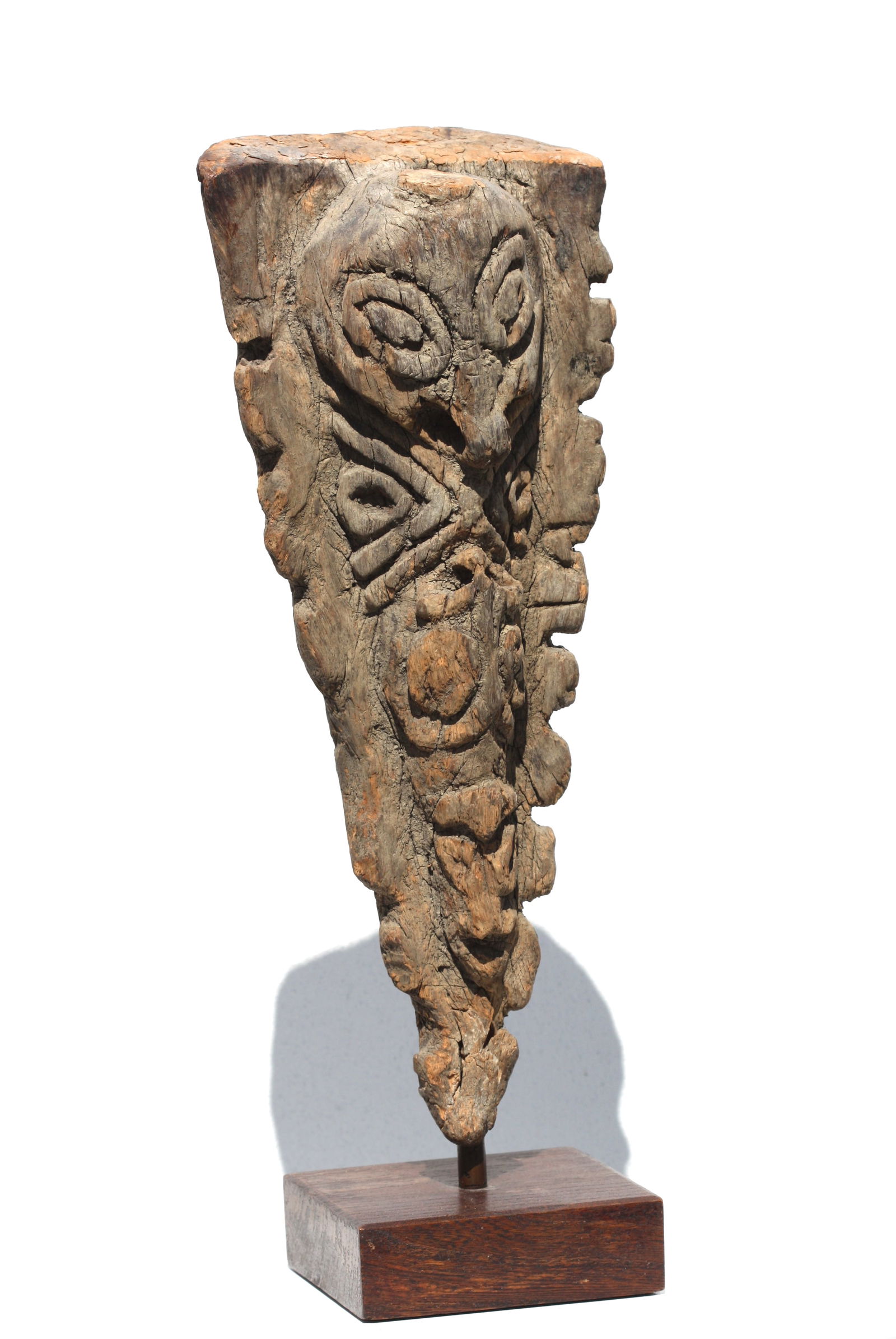 Oceanic Carved Wood Architectural Element: Oceanic Carved Wood Architectural Element The triangular shaped totem like element carved with a mythical mask, on a wood stand. Height 16.75 in., Width 7 in., Depth 4 in., overall, Height 19 in.