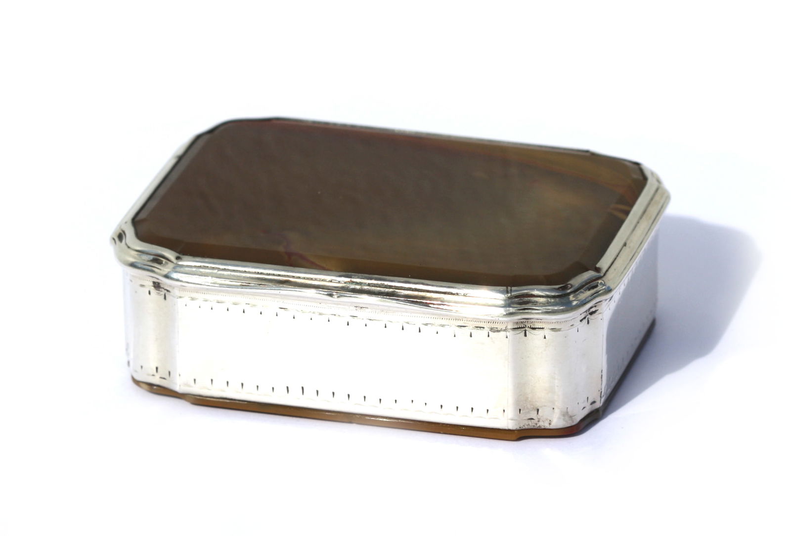 European Silver Mounted Agate Covered Box: European Silver Mounted Agate Covered Box Unmarked. The hinged lid with conforming body and shaped corners, the silver sides bright cut with borders, the faceted amber colored agate top and bottom