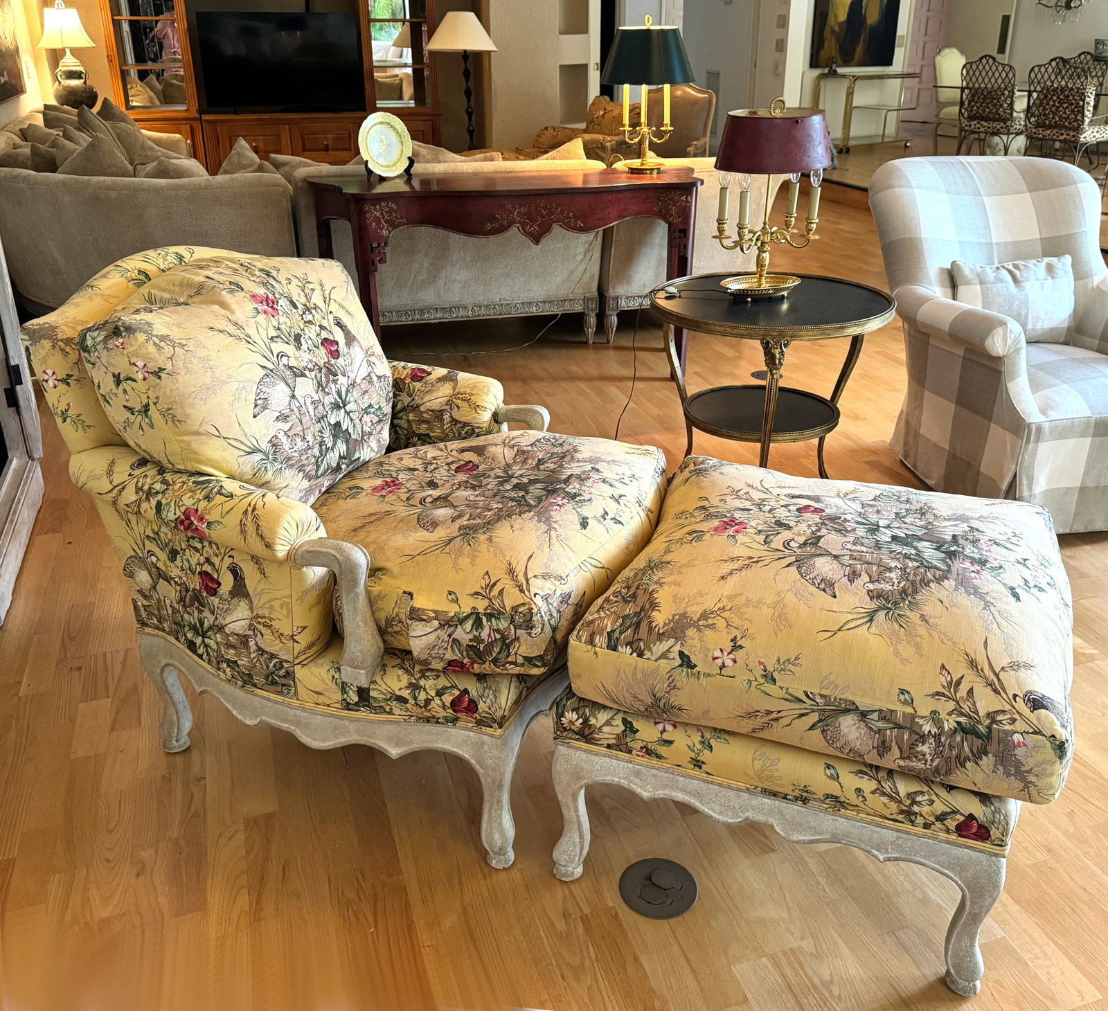 Louis XV Style Chintz Upholstered Bergere and Ottoman: Louis XV Style Chintz Upholstered Bergere and Ottoman The arch crest with rolled arms and a loose cushion, on white painted shaped rails and cabriole legs, both upholstered in a colorful foliate chint