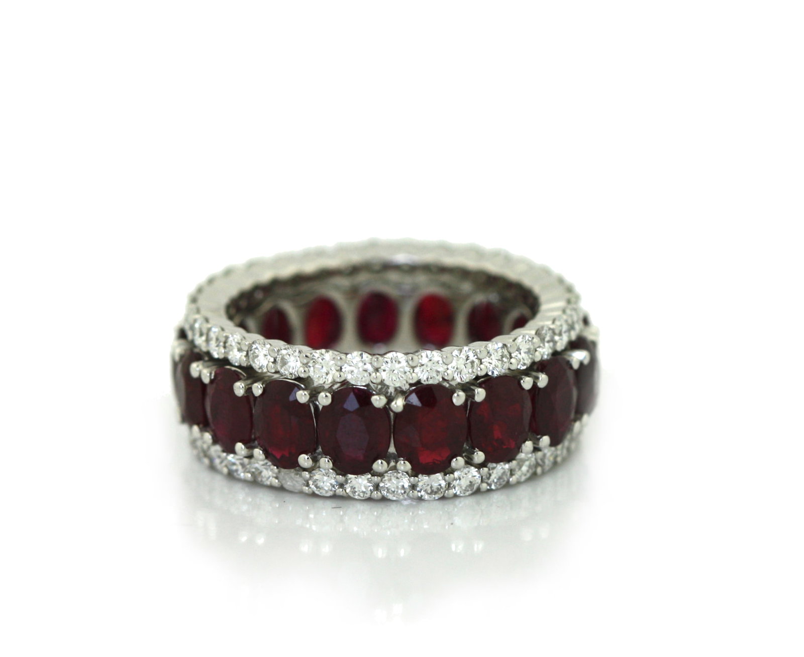 Platinum Ruby and Diamond Eternity Band Ring.: Platinum Ruby and Diamond Eternity Band Ring. Designed as a continuous eternity band set with seventeen oval mixed-cut rubies weighing approximately 7.14 carats total, accented by sixty-eight round br