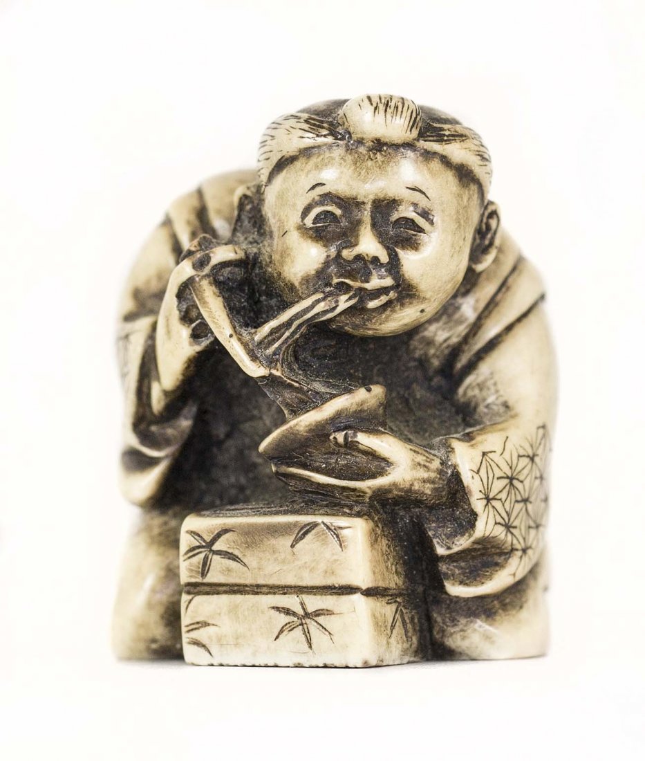 CARVED IVORY NETSUKE: PROPERTY FROM A FLORIDA COLLECTION CARVED IVORY NETSUKE Of a kneeling man, eating a bowl of noodles with chopsticks. Height 1 1/2 inches.